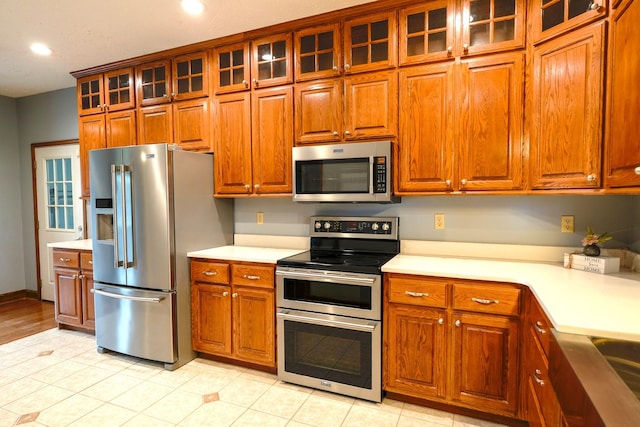 kitchen featuring stainless steel appliances and light tile patterned flooring