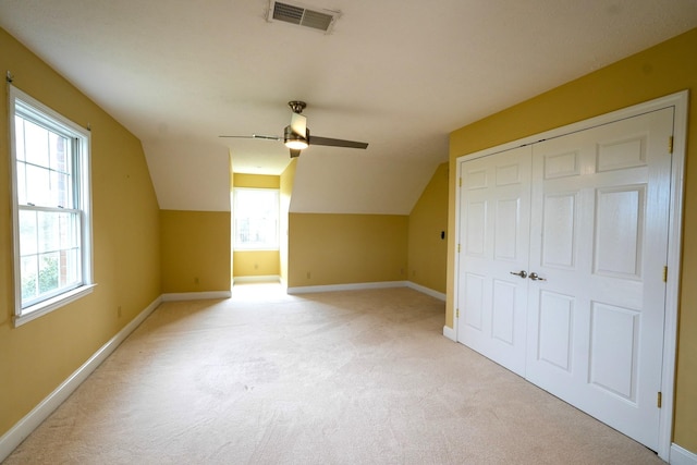 bonus room with ceiling fan, light colored carpet, vaulted ceiling, and a healthy amount of sunlight