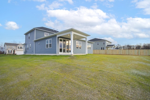 rear view of house featuring a yard