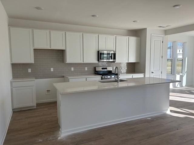 kitchen featuring a kitchen island with sink, appliances with stainless steel finishes, sink, and white cabinetry