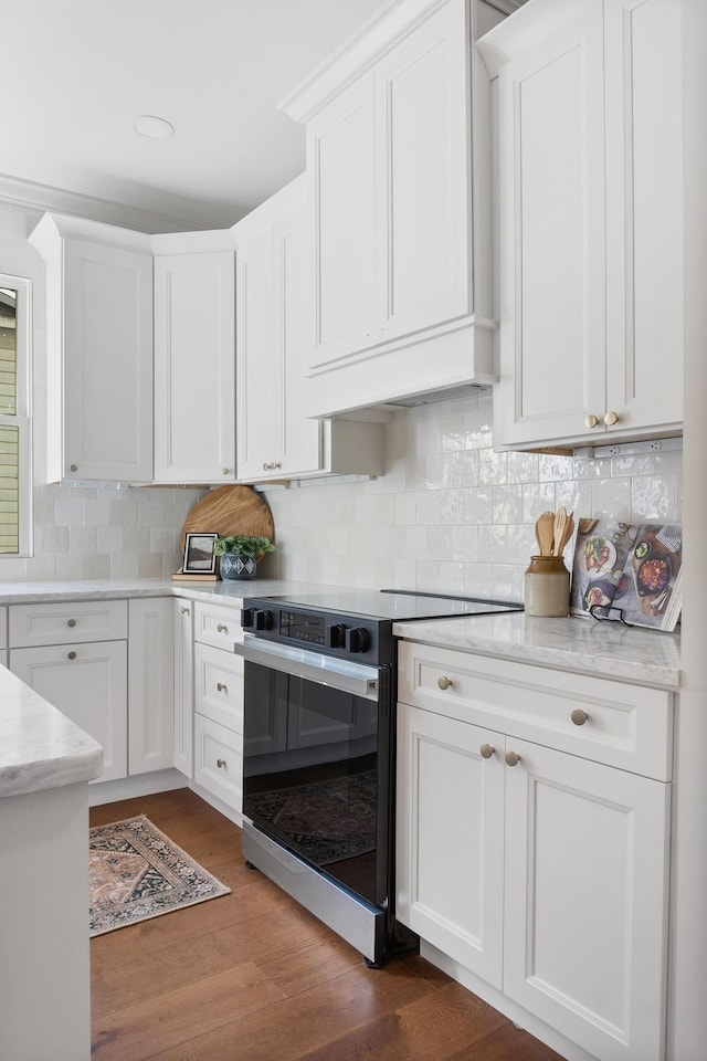 kitchen with electric stove, dark wood-type flooring, white cabinetry, backsplash, and custom range hood