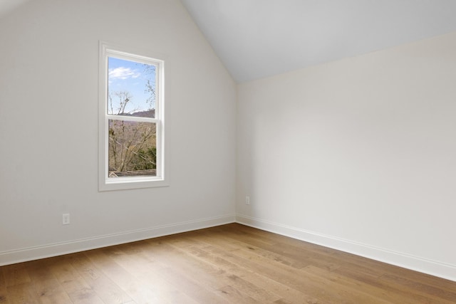 additional living space with vaulted ceiling, light wood-style flooring, and baseboards