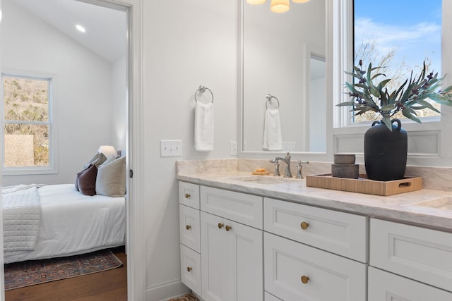 bathroom featuring lofted ceiling, recessed lighting, vanity, ensuite bath, and wood finished floors