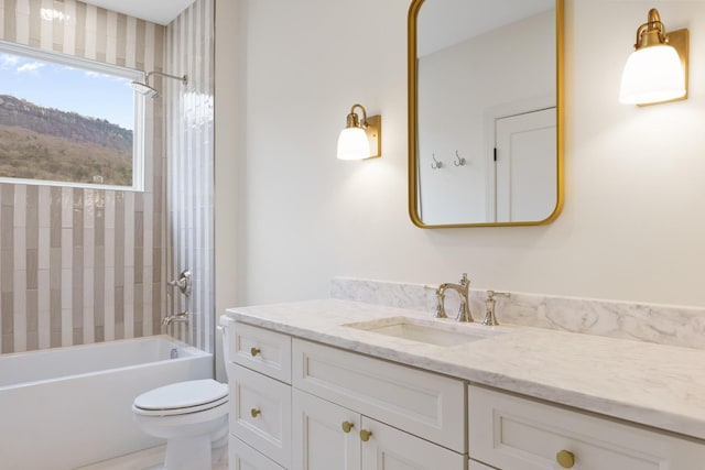 full bathroom with tiled shower / bath, vanity, and toilet