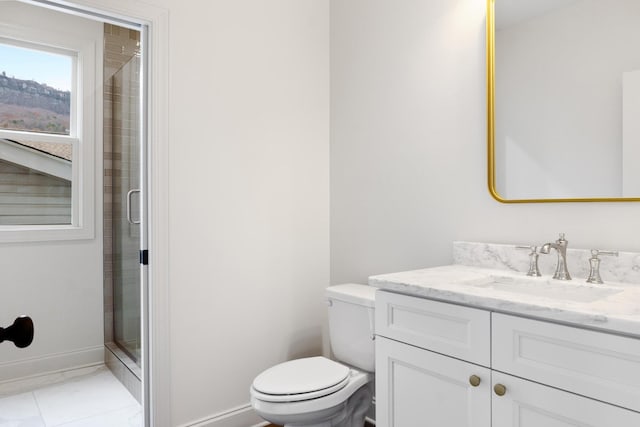 bathroom featuring toilet, a stall shower, baseboards, and vanity