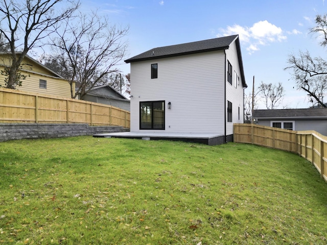 back of property featuring a lawn, a fenced backyard, and a wooden deck