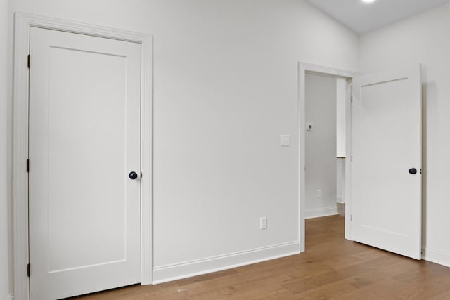 unfurnished bedroom with baseboards and wood finished floors