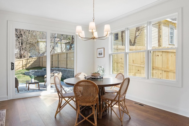 dining room featuring a healthy amount of sunlight, visible vents, baseboards, and hardwood / wood-style floors