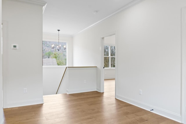 empty room featuring hardwood / wood-style flooring, ornamental molding, and plenty of natural light