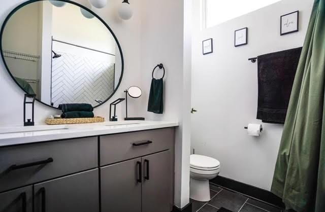 bathroom featuring toilet, vanity, and tile patterned flooring