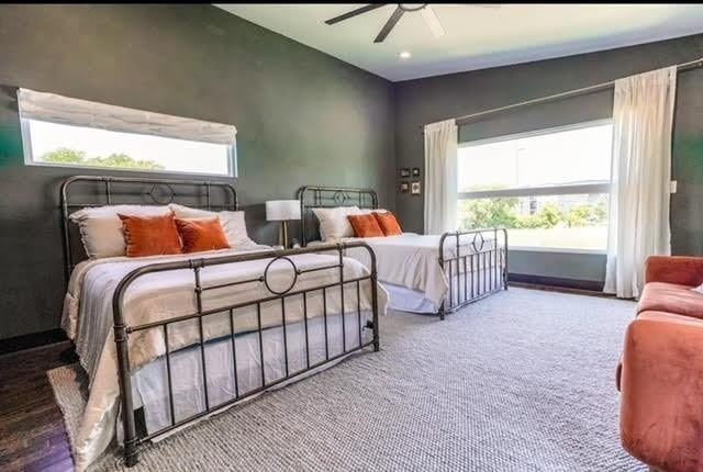 carpeted bedroom with vaulted ceiling and ceiling fan