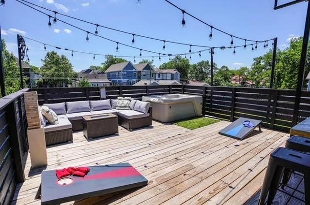 wooden terrace featuring outdoor lounge area and an outdoor hot tub