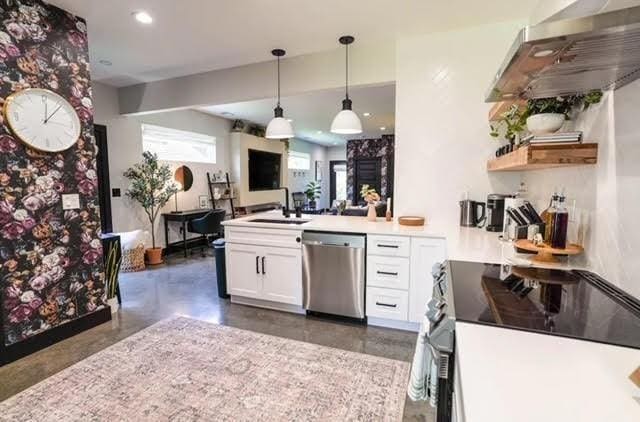 kitchen featuring pendant lighting, sink, appliances with stainless steel finishes, white cabinets, and ventilation hood