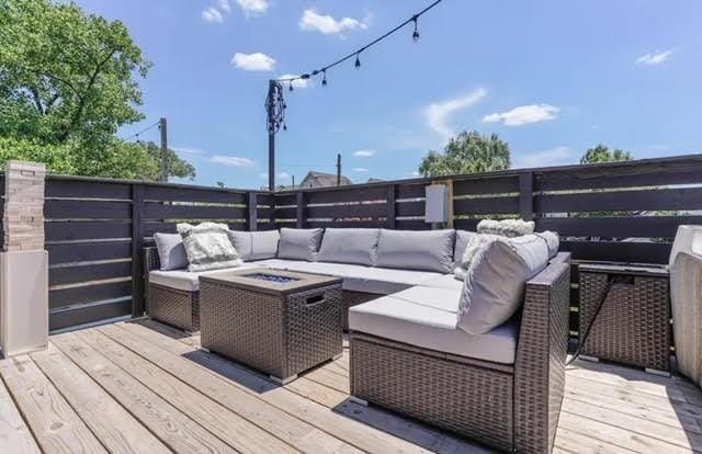 wooden deck with an outdoor living space with a fire pit