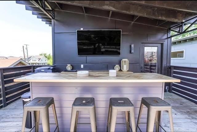 bar with vaulted ceiling and hardwood / wood-style floors