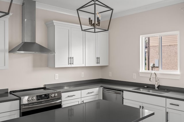 kitchen with white cabinets, wall chimney exhaust hood, stainless steel appliances, sink, and hanging light fixtures