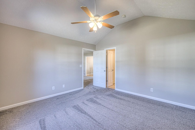 empty room with vaulted ceiling, ceiling fan, a textured ceiling, and light colored carpet