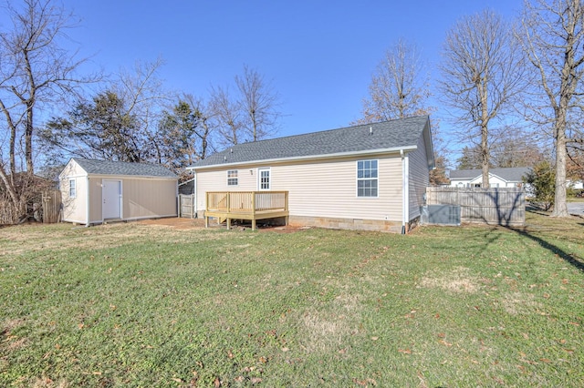 rear view of house featuring a deck, a storage unit, and a lawn