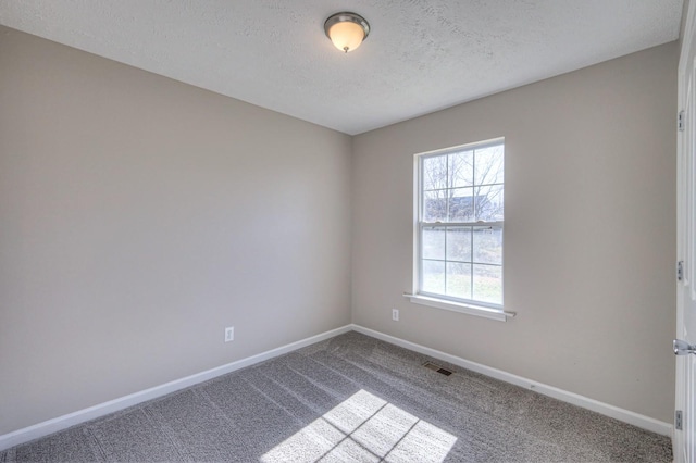 carpeted spare room with a textured ceiling