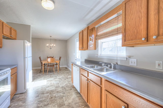 kitchen with a chandelier, sink, decorative light fixtures, and white appliances