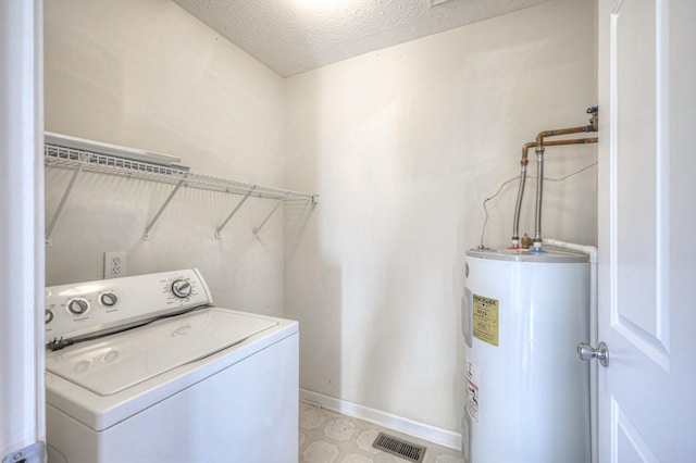 clothes washing area with water heater, a textured ceiling, and washer / clothes dryer