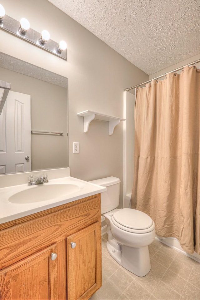 bathroom featuring a textured ceiling, toilet, and vanity