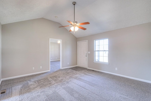 empty room featuring ceiling fan, a textured ceiling, carpet, and lofted ceiling