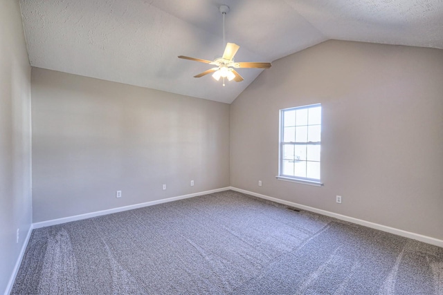 spare room featuring carpet, vaulted ceiling, and a textured ceiling