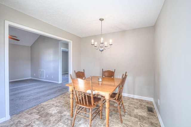 carpeted dining area featuring a textured ceiling and a notable chandelier