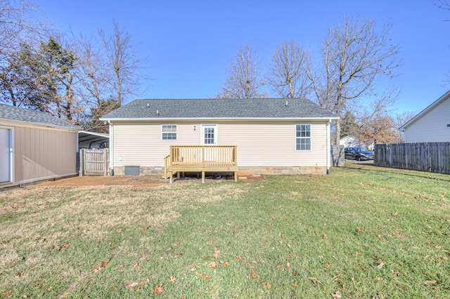 back of house featuring a lawn, a carport, and a wooden deck