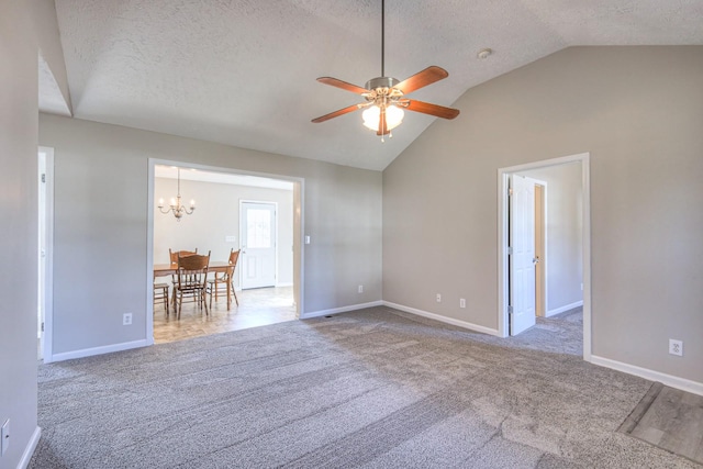 unfurnished room with light carpet, vaulted ceiling, ceiling fan with notable chandelier, and a textured ceiling