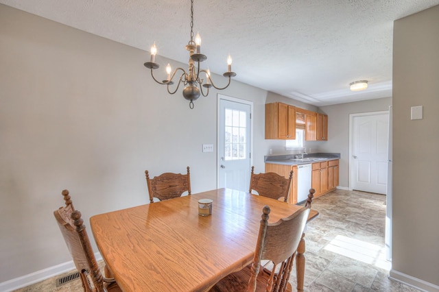 dining area featuring sink, a textured ceiling, and an inviting chandelier