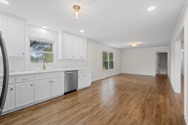 kitchen with white cabinetry, stainless steel appliances, decorative backsplash, a wealth of natural light, and sink