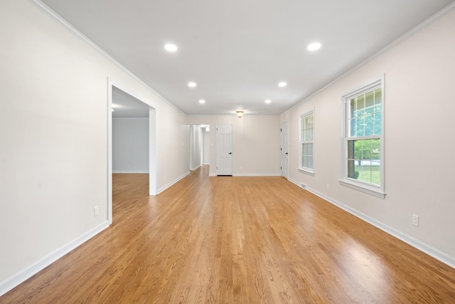 unfurnished living room featuring crown molding and light hardwood / wood-style floors