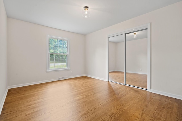 unfurnished bedroom with a closet and hardwood / wood-style flooring