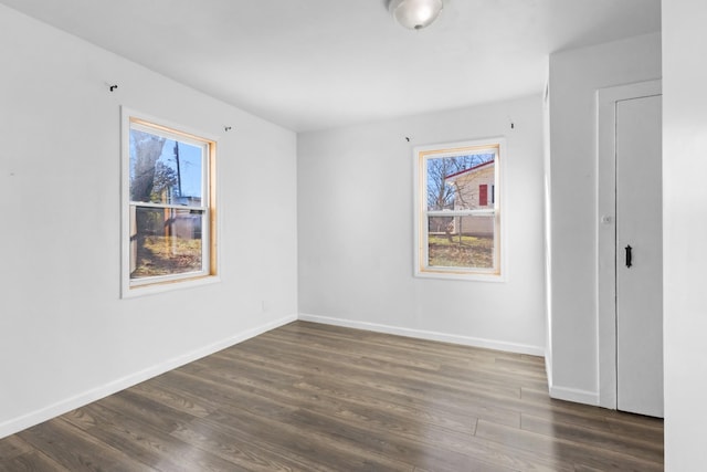 unfurnished room with dark hardwood / wood-style flooring