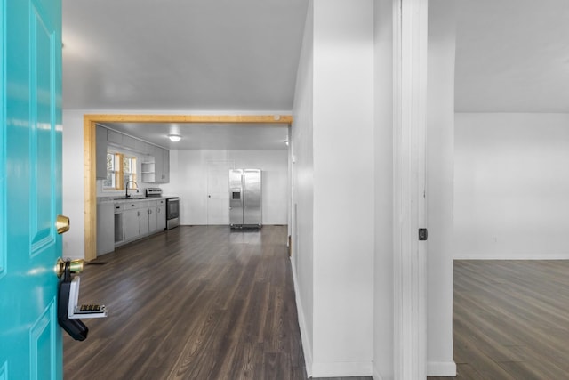 corridor with dark hardwood / wood-style flooring and sink