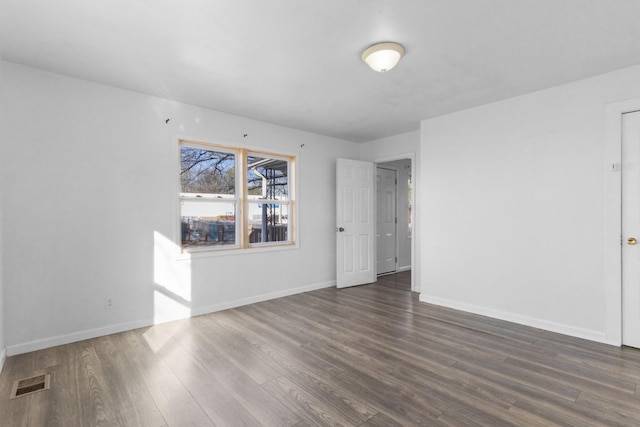 spare room with dark wood-type flooring