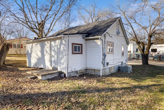 view of side of property featuring a lawn and central AC unit