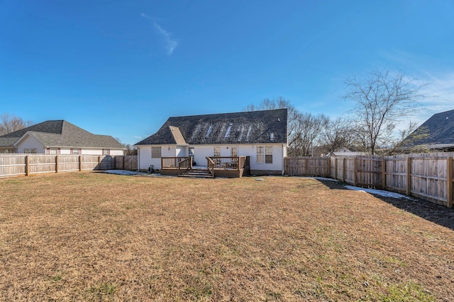 back of property featuring a lawn and a deck