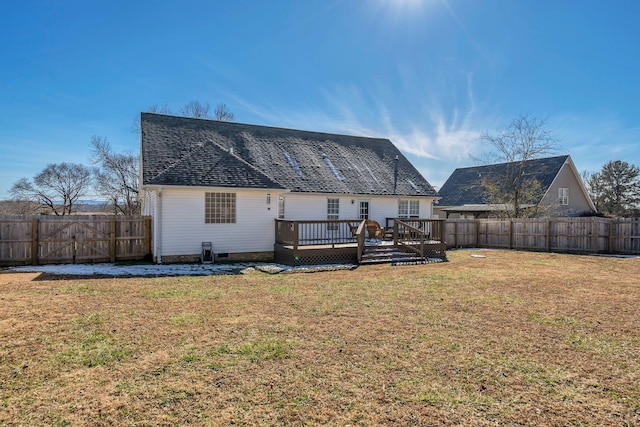 rear view of house featuring a deck and a yard