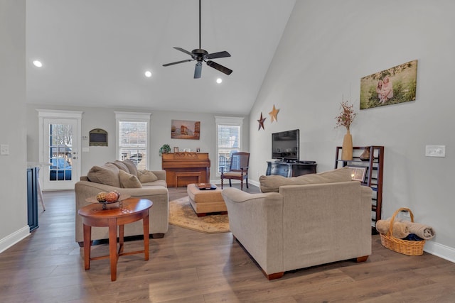 living room with ceiling fan, wood-type flooring, and high vaulted ceiling