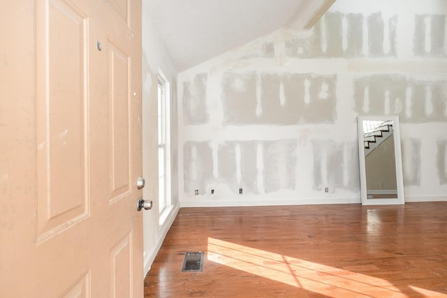 entrance foyer with vaulted ceiling and hardwood / wood-style floors