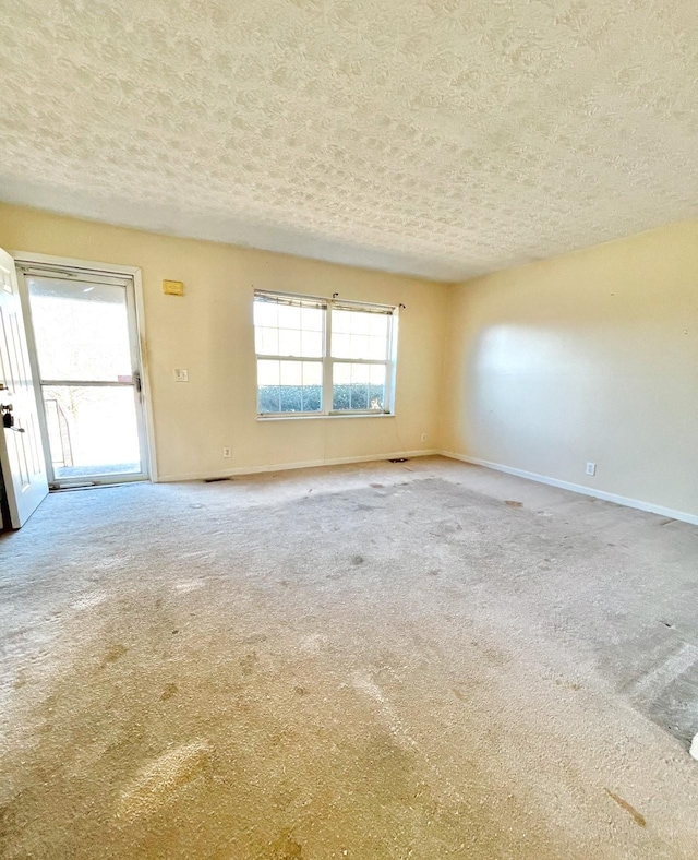 carpeted spare room featuring a textured ceiling