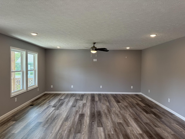 spare room with a textured ceiling, ceiling fan, and dark hardwood / wood-style flooring