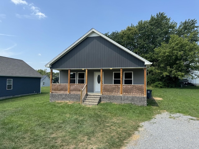 bungalow-style home featuring covered porch and a front lawn