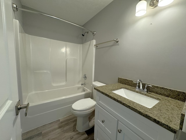 full bathroom with toilet, vanity, shower / bathing tub combination, wood-type flooring, and a textured ceiling