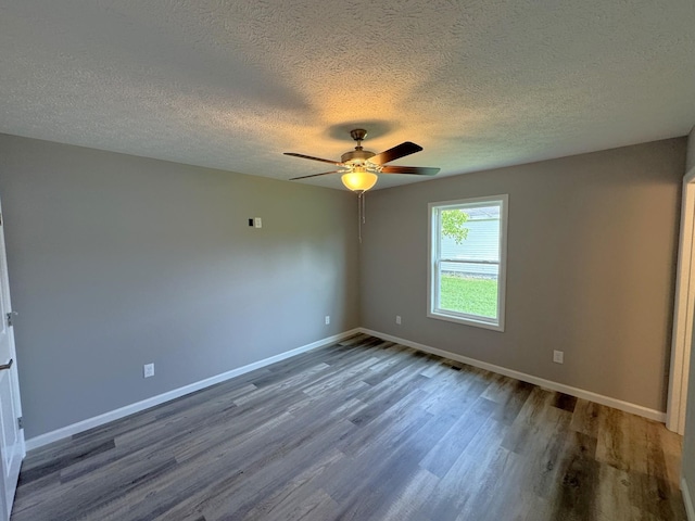 unfurnished room featuring ceiling fan, dark wood-type flooring, and a textured ceiling