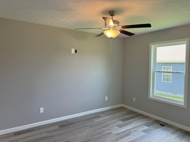 spare room with a textured ceiling, ceiling fan, and hardwood / wood-style floors