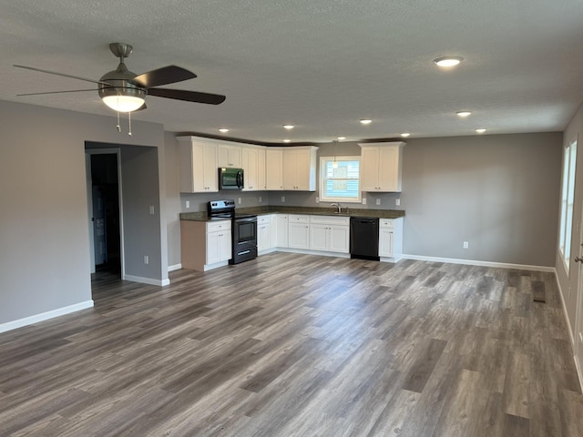 kitchen featuring white cabinets, dark wood-type flooring, stainless steel appliances, and a textured ceiling